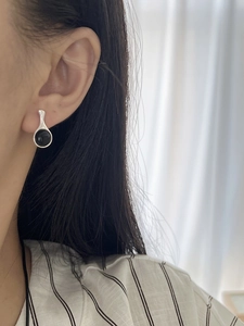 Close-up of minimalist S925 silver stud earring with black onyx on model's ear