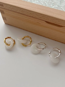 Detail of bamboo joint earrings with white agate donut charms in gold and silver finish