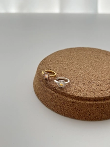 Detail of flower ear cuff featuring iridescent stone and small zircon petals in two colors
