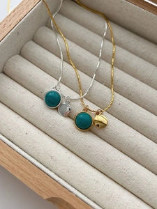 Close-up of 925 sterling silver turquoise pendants with hammered metal discs