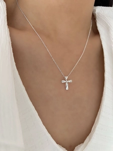 Close-up of a S925 sterling silver cross necklace worn on a woman's neck for a minimalist look