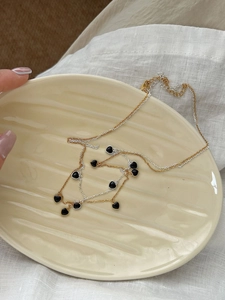 Détail d'un collier double épaisseur avec pendentifs coeurs noirs sur assiette céramique