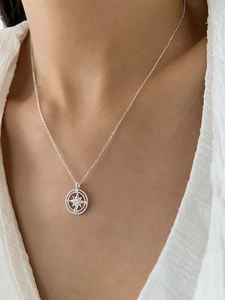 Detailed view of an elegant silver star necklace with crystals worn on collarbone