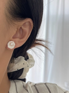 Gros plan sur les puces d'oreilles perle hexagonales argentées portées par un mannequin