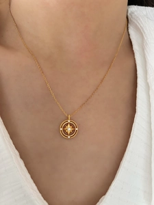 Macro detail of a gold hexagram star necklace featuring sparkling white zircon accents