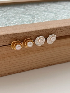 Détail de boucles d'oreilles lotus en perles géométriques dorées et argentées