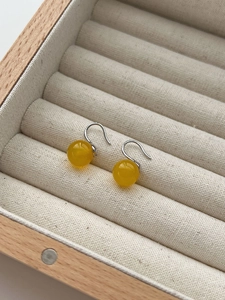 Macro detail of 925 sterling silver hooks with yellow agate beads in a jewelry box