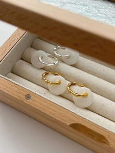 Detailed macro view of bamboo texture metal hoops with white agate donut charms