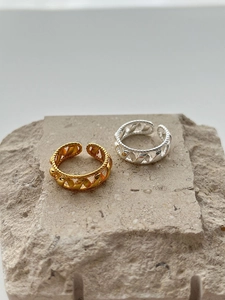 Detail of gold and silver S925 sterling silver rings with twisted rope and chain design