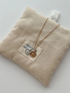 Detailed view of sterling silver and gold starburst compass necklaces on corduroy