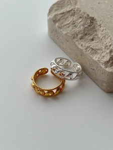 Macro shot of S925 sterling silver twist rings in gold and silver on stone
