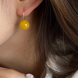 925 sterling silver hook earrings featuring polished yellow agate beads on a model