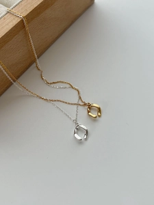Detailed view of minimalist irregular ring pendants in gold and silver on delicate O-chains