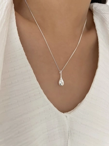 Gros plan d'un collier en argent S925 minimaliste avec pendentif bouteille de vin sur modèle