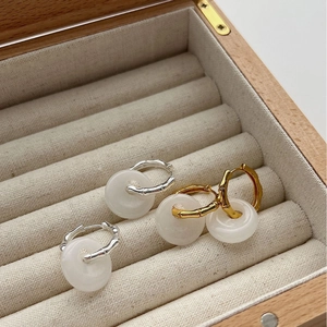 Bamboo style silver earrings with white agate donut charms in a jewelry box