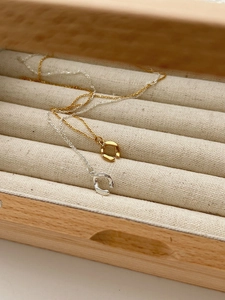 Detail of minimalist S925 sterling silver irregular horseshoe pendants in gold and silver