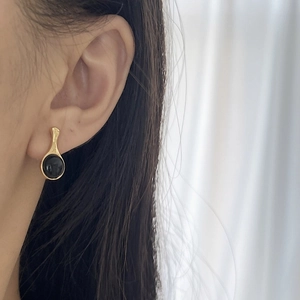 Minimalist 925 sterling silver earrings with black onyx on model in golden finish
