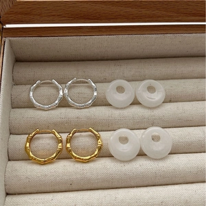 Bamboo style silver earrings with natural white agate donut charms in a jewelry box