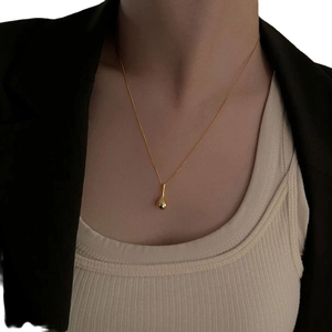 Collier minimaliste en argent S925 doré avec pendentif goutte d'eau porté par un modèle