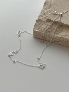 Detail of S925 sterling silver chain with five hollow heart pendants and hallmark