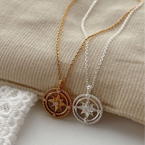 Elegant gold and silver star necklaces with zircons on textured corduroy fabric