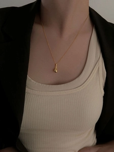 Gros plan d'un pendentif gourde en or sur une fine chaîne en argent S925 sterling