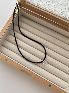 Détail du collier en argent S925 avec perles d'onyx noir et pendentif noeud élégant