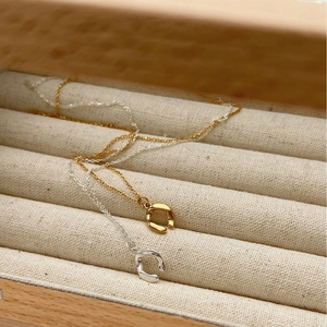 Irregular U-shaped S925 silver necklaces in gold and silver finish on beige fabric