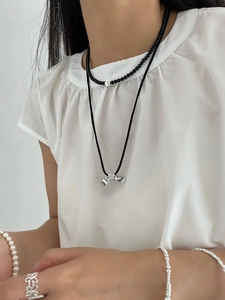 Détail du collier pendentif noeud en argent s925 et ras du cou onyx noir sur mannequin