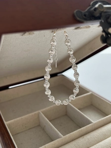Macro shot of S925 silver cat-eye bead bracelet with elegant lobster clasp on wood box