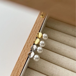 Elegant gold and silver pearl stud earrings with minimalist geometric design in jewelry box