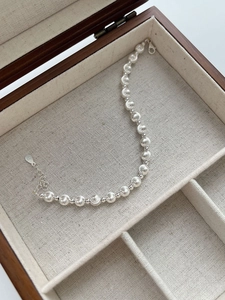 Detail of S925 sterling silver beaded bracelet with hallmark tag in a wooden box