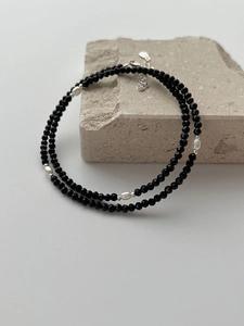Detail of s925 silver beaded necklace with black faceted beads and white oval pearls