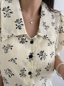 Detail of vintage cream shirt with black rose print and elegant oversized pointed collar