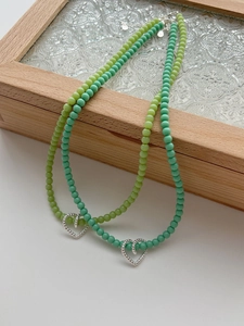 Close-up of handmade 925 silver hollow heart charms on colorful beaded necklaces