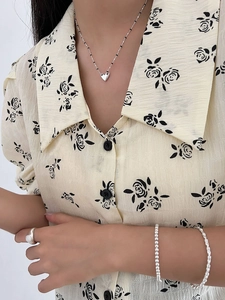 Detail of S925 silver heart necklace and retro ring set worn with vintage shirt