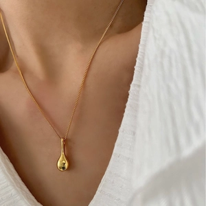 Élégant collier avec pendentif goutte d'eau en argent S925 doré porté par un mannequin