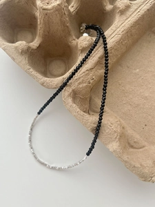 Detail of faceted black onyx and irregular silver beads on a handcrafted necklace