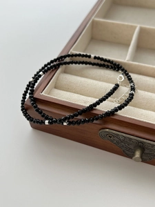 Macro view of multi-layered black faceted spinel beaded necklace with silver spacer beads