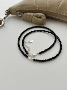 Detail of S925 silver necklace with black spinel beads and a white pearl accent