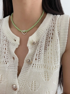Detail of 925 sterling silver beaded heart necklace worn with white knit cardigan