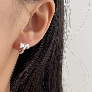 Elegant 925 sterling silver bow knot hoop earrings for women shown on ear model