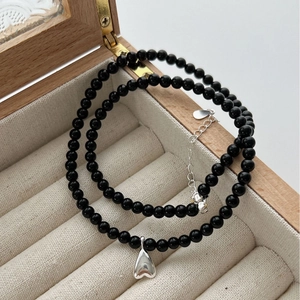 Black agate beaded necklace with silver heart pendant in a wooden jewelry box