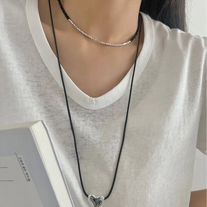 Double-layered sterling silver heart necklace with black onyx beads on a model