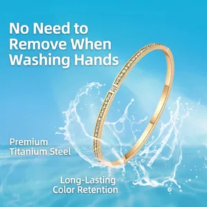 Elegant gold titanium steel bangle with shimmering pave crystals on a water wave background