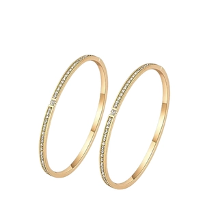 Elegant gold-plated stainless steel bangles with sparkling crystals on white background