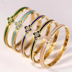 Set of five gold plated clover bangles with colorful enamel lines and sparkling zirconia