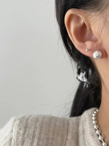 Macro shot of S925 silver textured sphere earring featuring Midnight engraving detail
