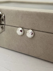 Detailed macro view of S925 sterling silver hammered texture earring with logo engraving