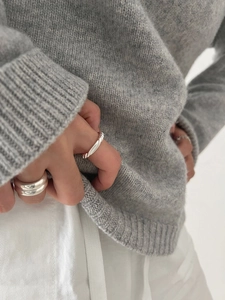 Close-up of minimalist 925 sterling silver knotted twist open rings worn on hand